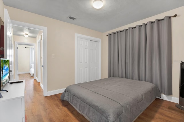 bedroom with light hardwood / wood-style floors and a closet