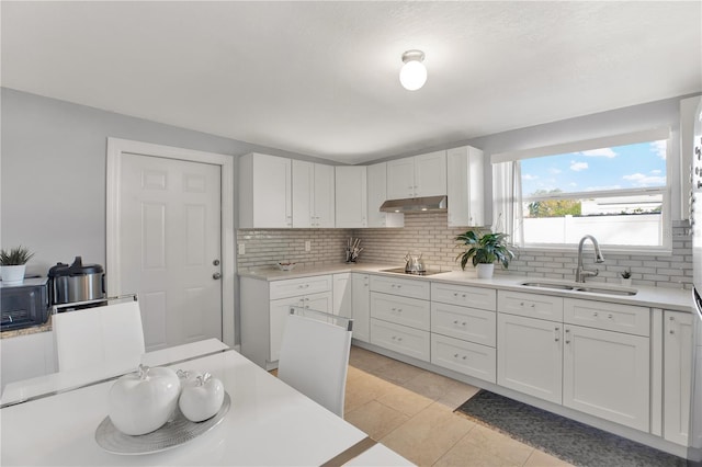 kitchen featuring tasteful backsplash, sink, black electric cooktop, and white cabinets