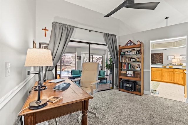 carpeted office space with ceiling fan