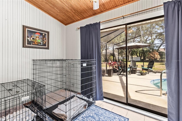 doorway featuring wood ceiling, lofted ceiling, plenty of natural light, and light tile patterned floors