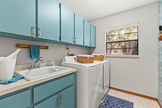 laundry area featuring separate washer and dryer, sink, cabinets, light tile patterned floors, and a textured ceiling