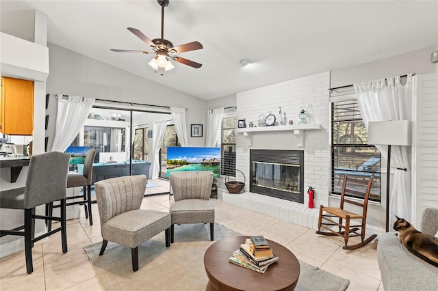 tiled living room featuring ceiling fan, lofted ceiling, and a brick fireplace