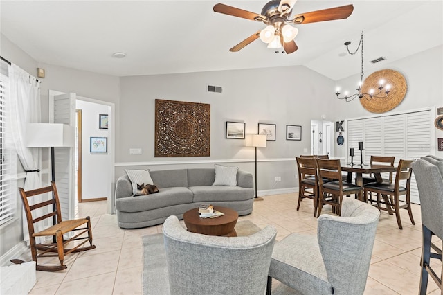 tiled living room with ceiling fan with notable chandelier and vaulted ceiling