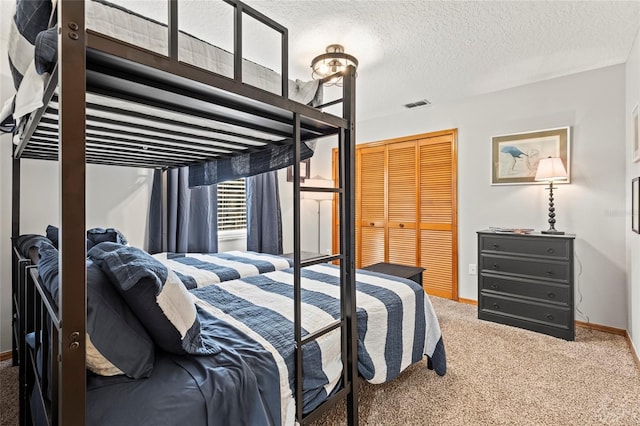 carpeted bedroom featuring a closet and a textured ceiling