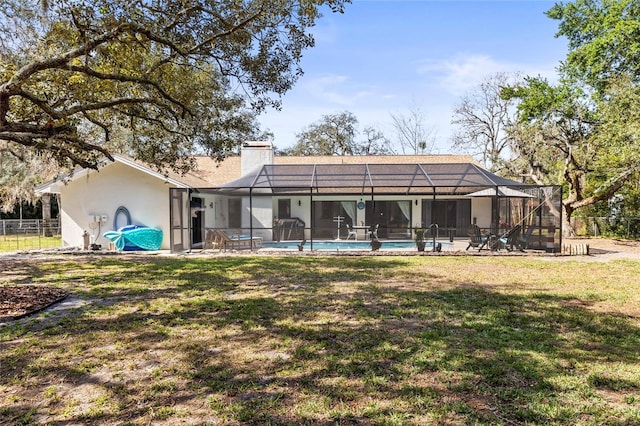 rear view of house with glass enclosure and a lawn