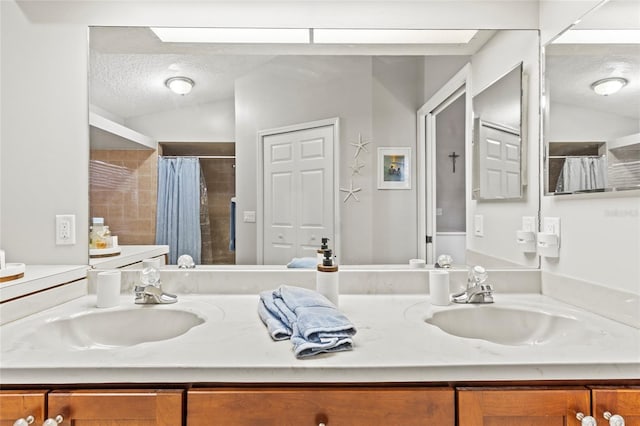 bathroom featuring a shower with curtain, vanity, vaulted ceiling with skylight, and a textured ceiling