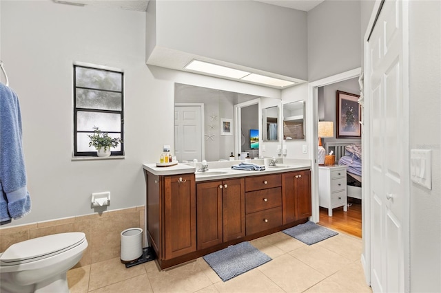 bathroom with vanity, tile walls, tile patterned floors, and toilet