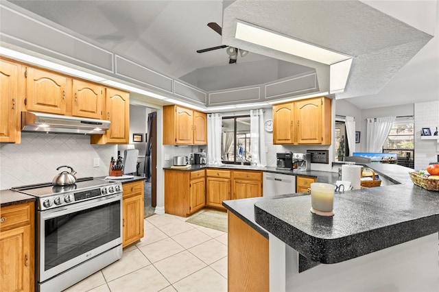 kitchen featuring light tile patterned floors, ceiling fan, backsplash, stainless steel appliances, and kitchen peninsula