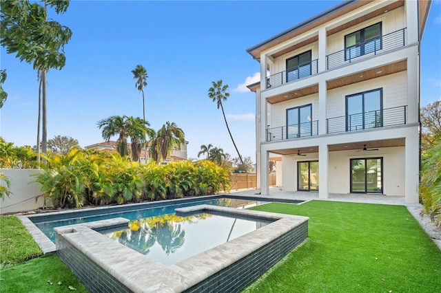 back of house with a balcony, a lawn, ceiling fan, a fenced in pool, and a patio area