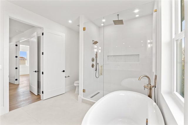 full bath featuring a stall shower, a soaking tub, toilet, and recessed lighting