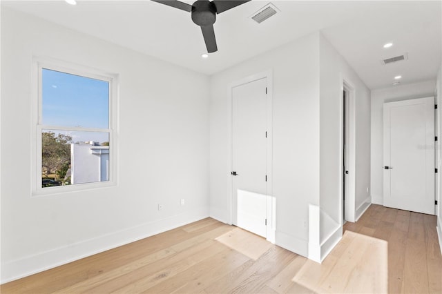 empty room featuring wood finished floors, visible vents, and baseboards