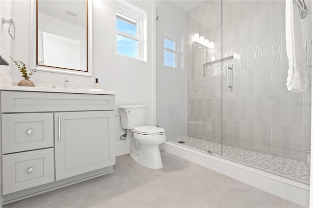 full bath featuring toilet, visible vents, vanity, a tile shower, and tile patterned floors