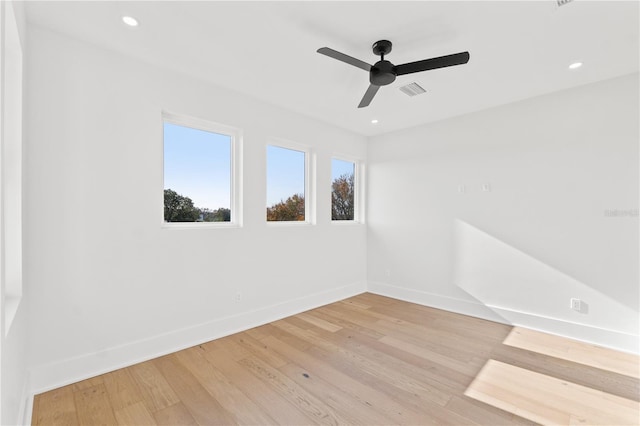 empty room with light wood-style floors, visible vents, baseboards, and recessed lighting