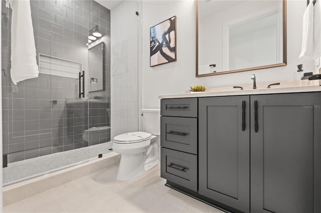 bathroom with tiled shower, vanity, toilet, and tile patterned floors