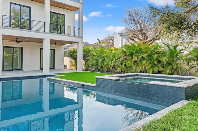 outdoor pool with a ceiling fan, a patio, and an in ground hot tub