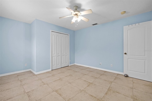 unfurnished bedroom with ceiling fan and a closet