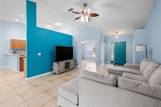 living room featuring lofted ceiling, sink, light tile patterned floors, and ceiling fan