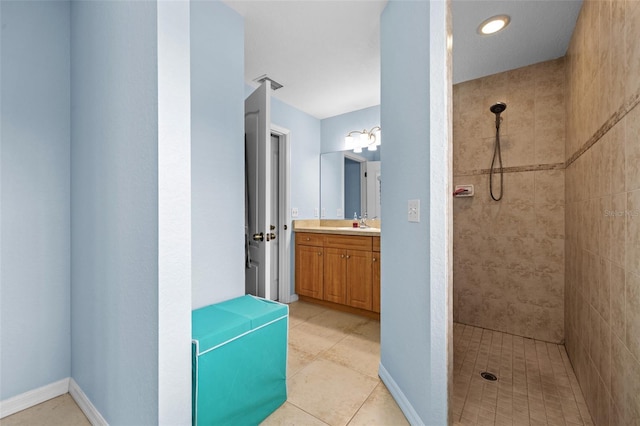 bathroom with vanity, a tile shower, and tile patterned floors