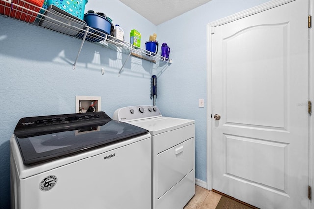 clothes washing area featuring washer and dryer and light hardwood / wood-style flooring