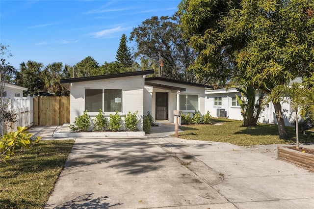 view of front facade with a front yard and central air condition unit