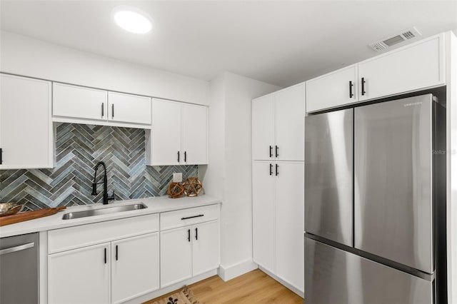 kitchen featuring sink, stainless steel appliances, and white cabinets