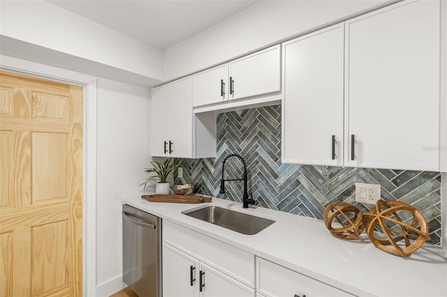 kitchen featuring sink, decorative backsplash, stainless steel dishwasher, and white cabinets