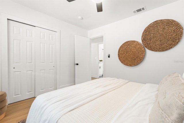 bedroom with light hardwood / wood-style flooring, a closet, and ceiling fan