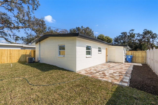 back of property featuring a patio, a yard, and central AC