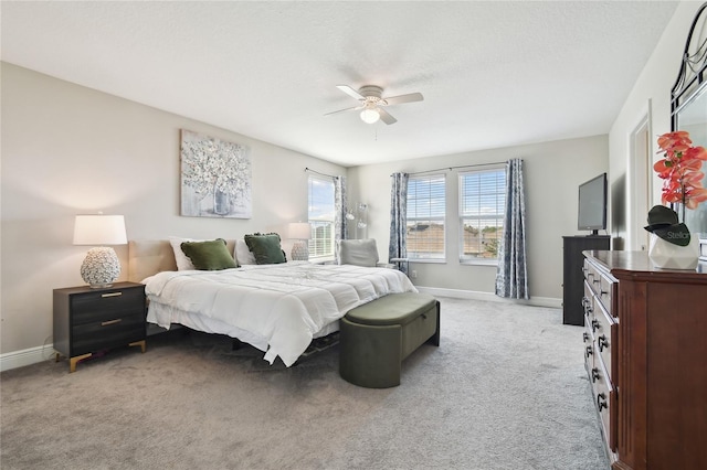 carpeted bedroom featuring ceiling fan and a textured ceiling