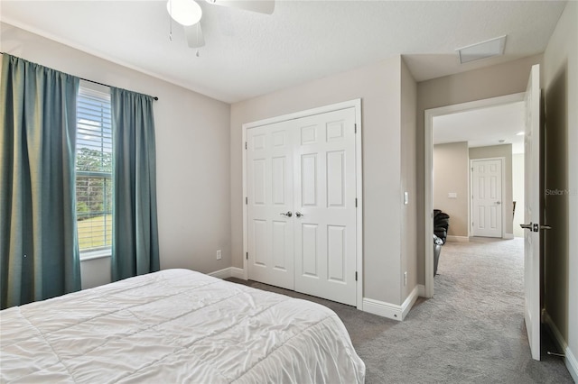 carpeted bedroom featuring ceiling fan and a closet