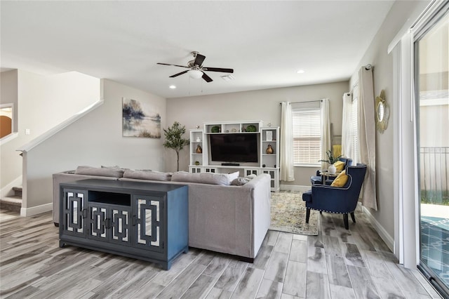 living room featuring ceiling fan and light hardwood / wood-style flooring