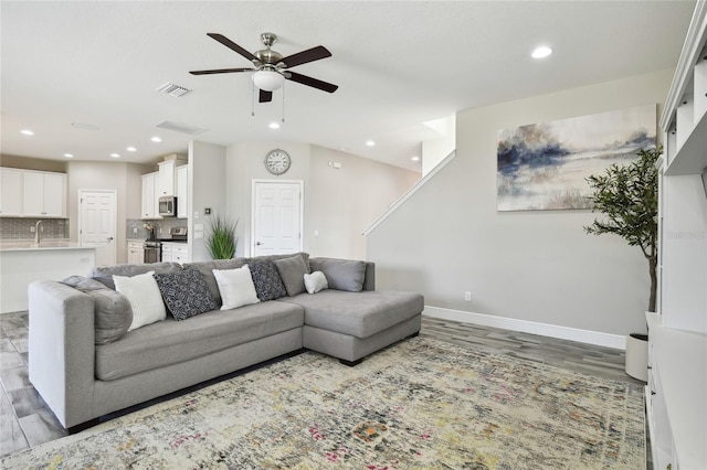 living room with hardwood / wood-style flooring, ceiling fan, and sink