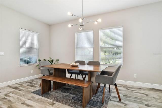 dining area featuring light wood-type flooring and a notable chandelier