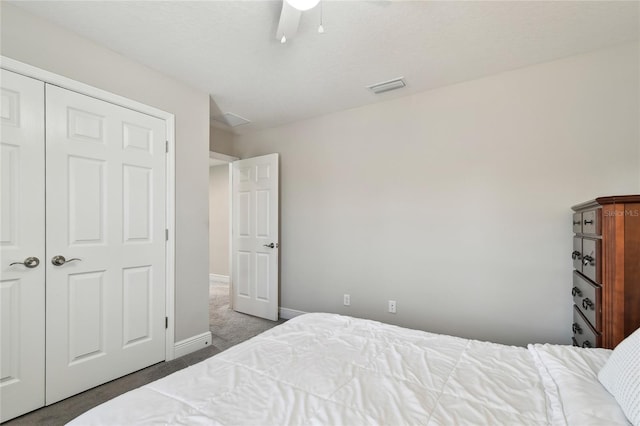 bedroom with ceiling fan, dark carpet, and a closet