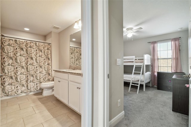 bathroom featuring ceiling fan, vanity, toilet, and tile patterned floors