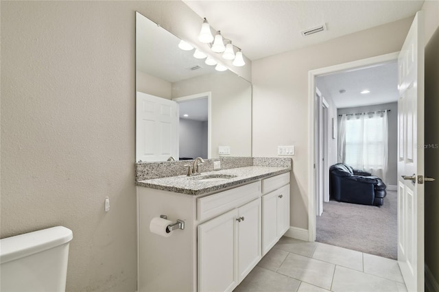 bathroom featuring vanity, toilet, and tile patterned flooring