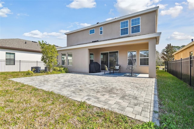 rear view of house featuring a lawn and a patio area