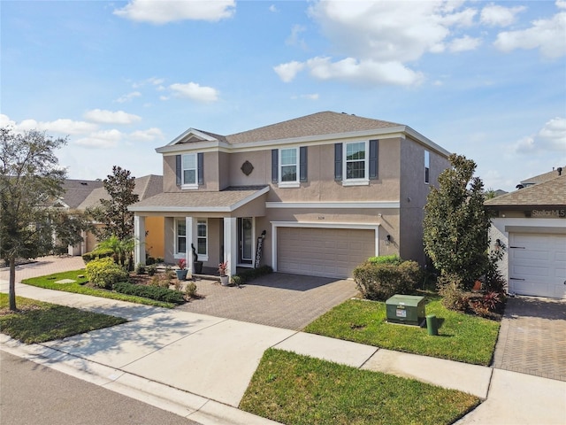 view of property featuring a garage and a front yard