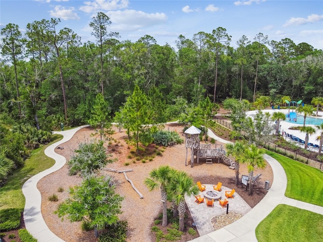 view of property's community with an outdoor fire pit and a playground