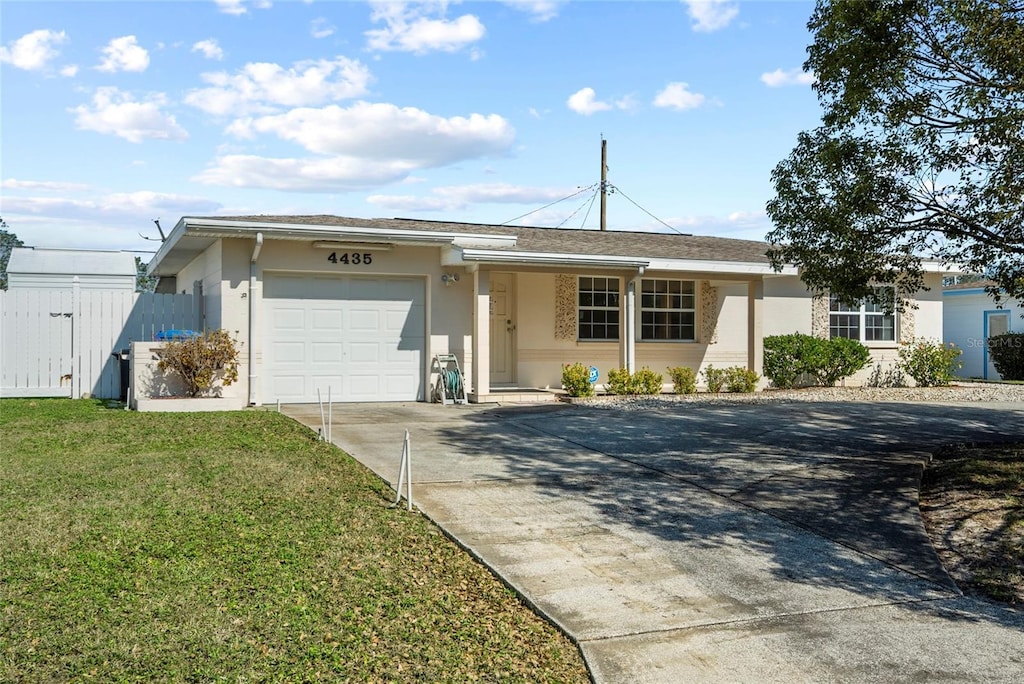 ranch-style house featuring a garage and a front lawn