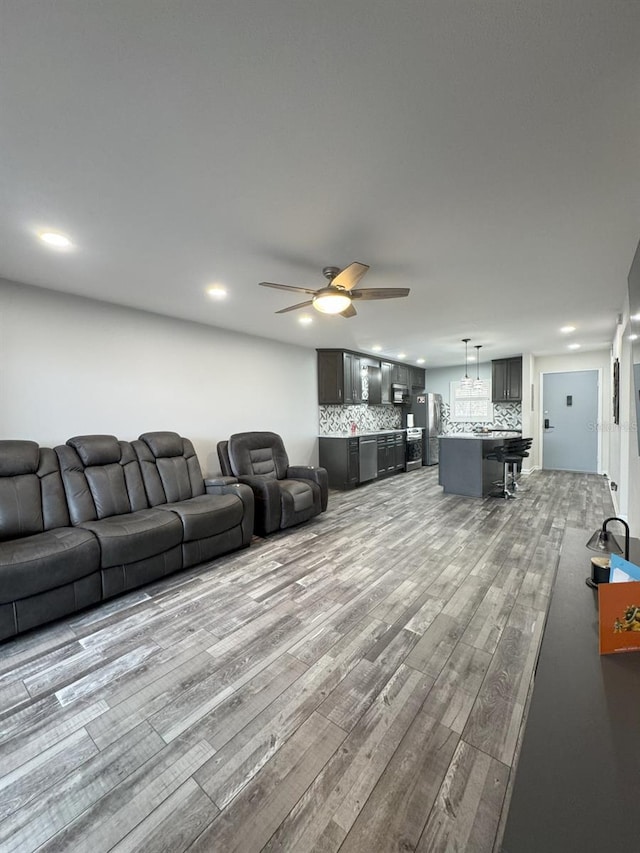 living room with ceiling fan and light wood-type flooring