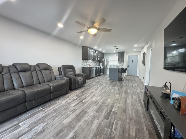 living room featuring ceiling fan and light hardwood / wood-style flooring