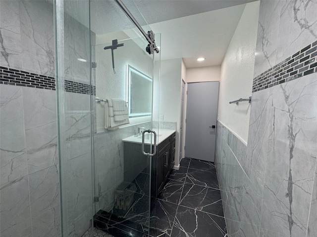 bathroom featuring vanity, tile walls, and a shower with shower door