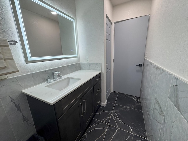 bathroom with vanity and tile walls