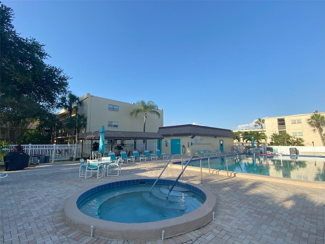 view of pool featuring a hot tub and a patio