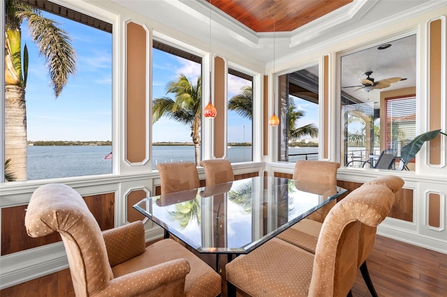 sunroom / solarium with a raised ceiling, a water view, and ceiling fan