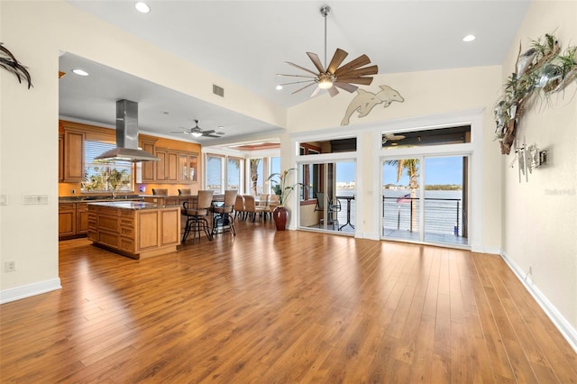 living room featuring lofted ceiling, ceiling fan, and light hardwood / wood-style flooring