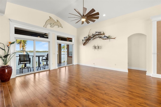 spare room featuring wood-type flooring, vaulted ceiling, ceiling fan, and a water view