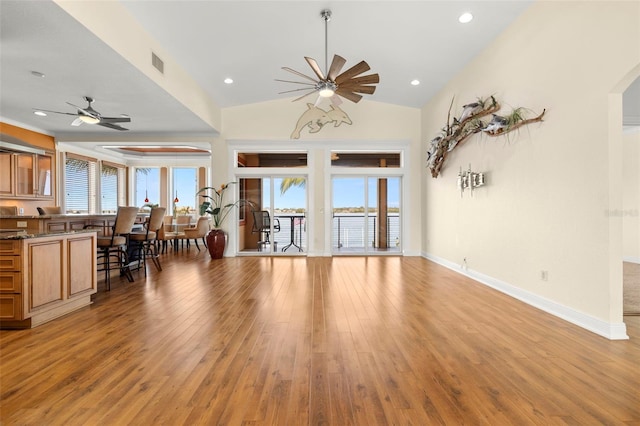 living room featuring lofted ceiling, light hardwood / wood-style flooring, and ceiling fan