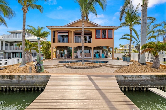 view of dock featuring a balcony, a water view, and a patio